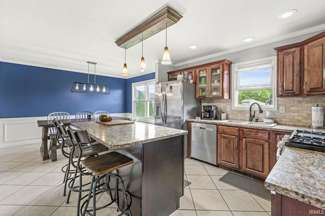 54062 Stonebridge Dr, Elkhart, IN 46514 - kitchen with appliances with stainless steel finishes, a sink, light tile patterned flooring, a kitchen island, and a breakfast bar area
