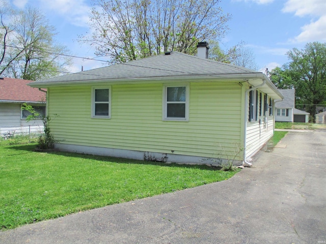 1103 S Jersey Ave, Muncie, IN 47302 - view of side of home featuring a chimney, a shingled roof, a lawn, and driveway