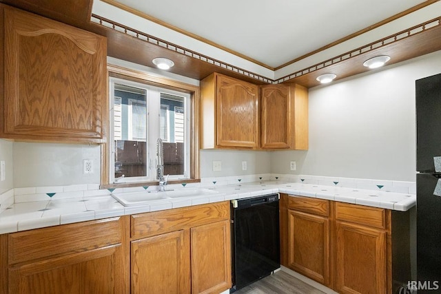 721 E Markland Ave, Kokomo, IN 46902 - kitchen with black dishwasher, a sink, ornamental molding, brown cabinetry, and light countertops