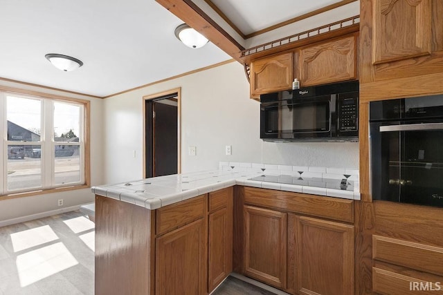 721 E Markland Ave, Kokomo, IN 46902 - kitchen featuring black appliances, a peninsula, brown cabinetry, ornamental molding, and tile counters