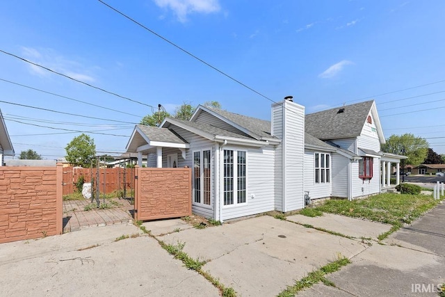 721 E Markland Ave, Kokomo, IN 46902 - rear view of house with a shingled roof, a chimney, and a gate