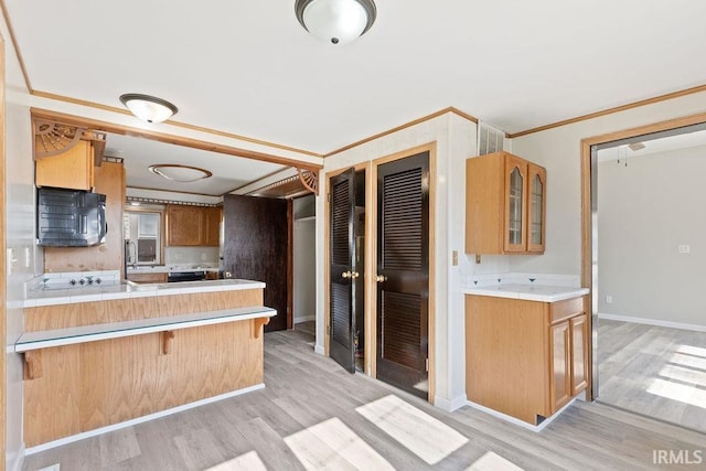 721 E Markland Ave, Kokomo, IN 46902 - kitchen featuring light wood-style flooring, glass insert cabinets, a kitchen breakfast bar, a peninsula, and ornamental molding
