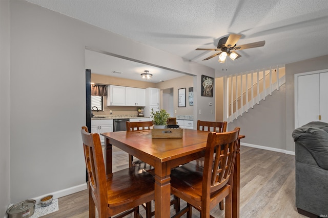 2106 Bayside Ct, Fort Wayne, IN 46804 - dining space featuring ceiling fan, stairs, light wood finished floors, a textured ceiling, and baseboards