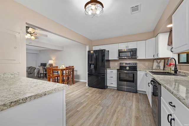 2106 Bayside Ct, Fort Wayne, IN 46804 - kitchen featuring black appliances, a sink, light wood-style floors, white cabinets, and baseboards