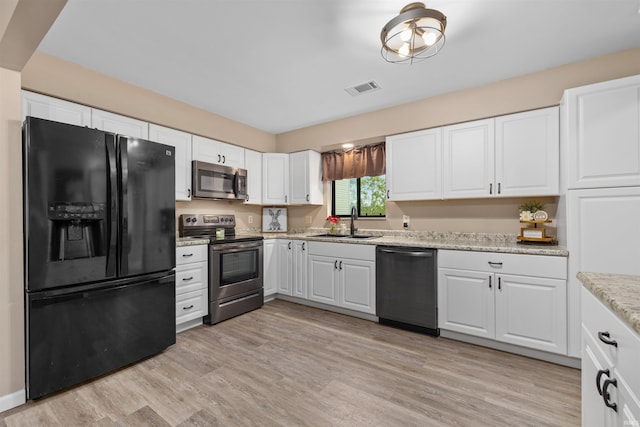 2106 Bayside Ct, Fort Wayne, IN 46804 - kitchen featuring appliances with stainless steel finishes, a sink, white cabinets, light wood finished floors, and light stone countertops