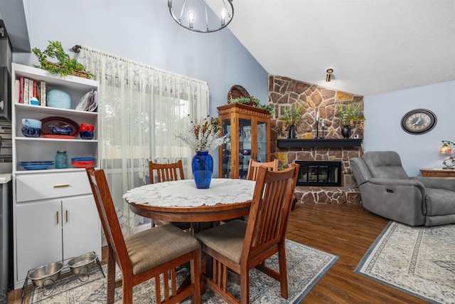 6008 Hinsdale Ln, Fort Wayne, IN 46835 - dining room featuring vaulted ceiling, a stone fireplace, and wood finished floors