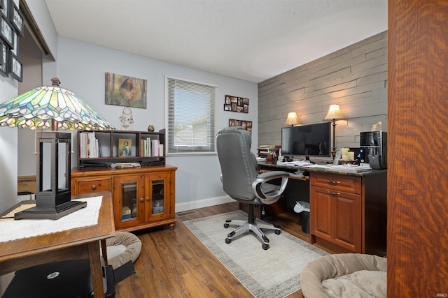 6008 Hinsdale Ln, Fort Wayne, IN 46835 - home office with dark wood finished floors, wood walls, an accent wall, and baseboards