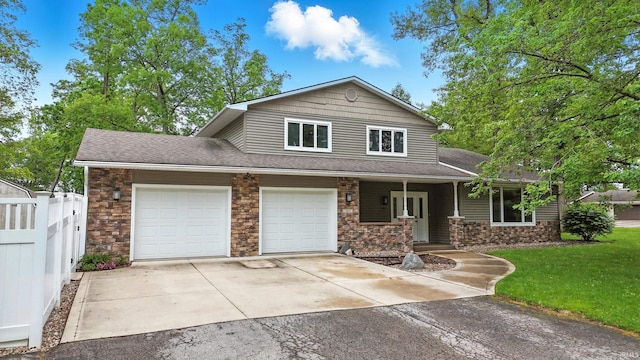 2882 E Hickory Ln, Columbia City, IN 46725 - view of front of home featuring stone siding, driveway, an attached garage, a shingled roof, and a porch
