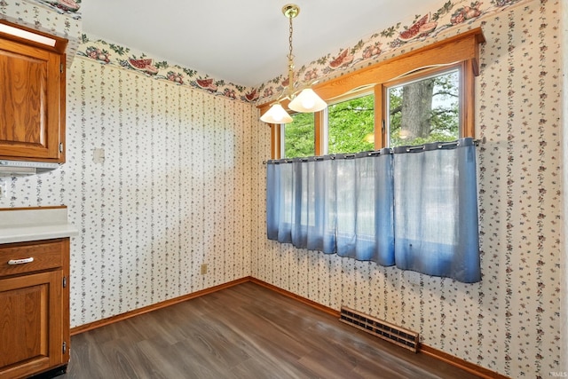 2882 E Hickory Ln, Columbia City, IN 46725 - unfurnished dining area with wallpapered walls, dark wood finished floors, and baseboards