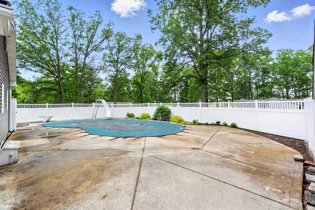 2882 E Hickory Ln, Columbia City, IN 46725 - view of swimming pool with a water slide, a patio, a fenced backyard, a diving board, and view of scattered trees