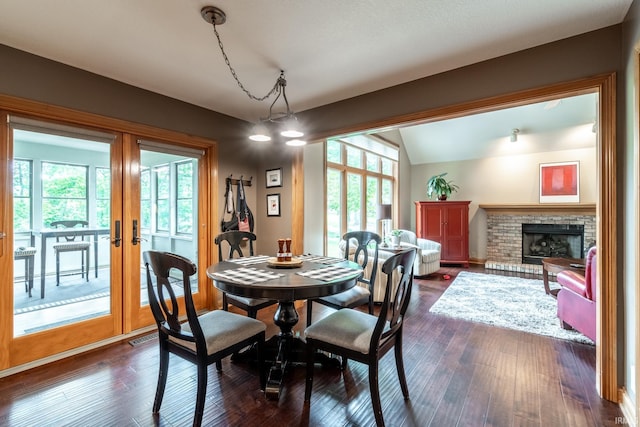 8505 Crenshaw Ct, Fort Wayne, IN 46835 - dining area featuring vaulted ceiling, a brick fireplace, dark wood-style floors, and french doors