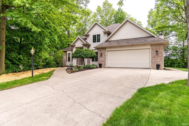 8505 Crenshaw Ct, Fort Wayne, IN 46835 - view of front facade with brick siding, driveway, an attached garage, and a chimney