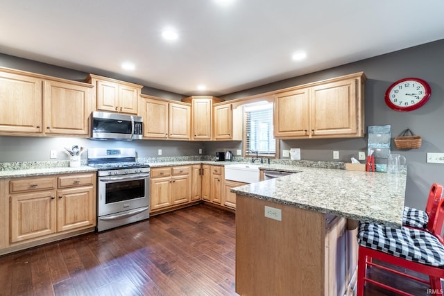 8505 Crenshaw Ct, Fort Wayne, IN 46835 - kitchen featuring light brown cabinetry, stainless steel appliances, a sink, a peninsula, and a kitchen breakfast bar