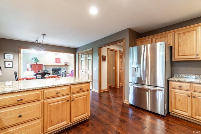 8505 Crenshaw Ct, Fort Wayne, IN 46835 - kitchen featuring stainless steel fridge, dark wood-style flooring, light stone countertops, and a fireplace