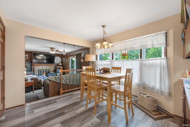9006 Forestdale Dr, New Haven, IN 46774 - dining area with wood finished floors, a chandelier, a fireplace, and a ceiling fan