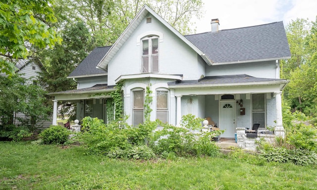 430 S Columbia St, Warsaw, IN 46580 - victorian home featuring covered porch, roof with shingles, a chimney, brick siding, and a front yard