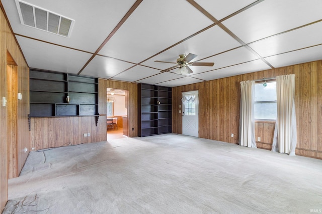 5460 N 550 E, Churubusco, IN 46723 - unfurnished living room with wooden walls, built in features, a ceiling fan, and carpet flooring