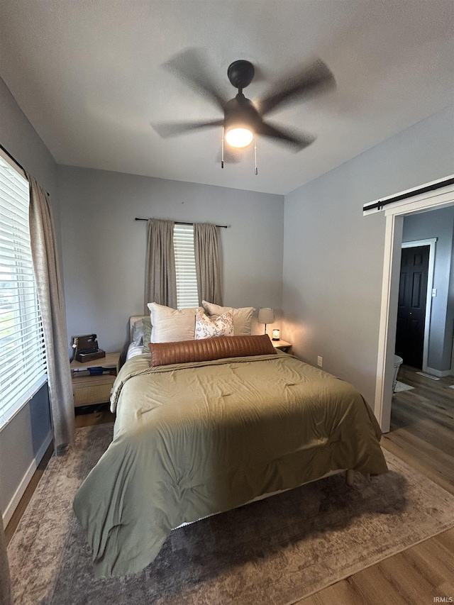 1301 E Spruce St, Petersburg, IN 47567 - bedroom with wood finished floors, a barn door, baseboards, and ceiling fan
