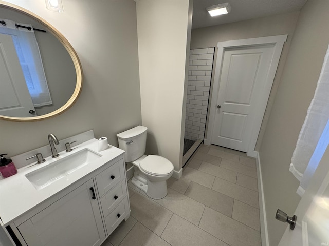 5317 Stellhorn Rd, Fort Wayne, IN 46815 - bathroom featuring vanity, toilet, a tile shower, tile patterned floors, and baseboards