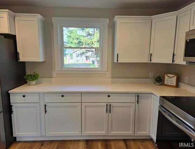 5317 Stellhorn Rd, Fort Wayne, IN 46815 - kitchen with white cabinetry, stainless steel microwave, electric range, and freestanding refrigerator