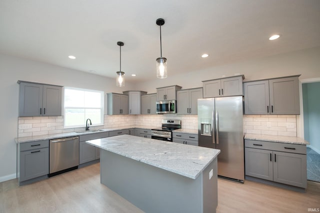 909 S Hoke Ave, Frankfort, IN 46041 - kitchen featuring stainless steel appliances, a sink, gray cabinets, light wood-type flooring, and a kitchen island
