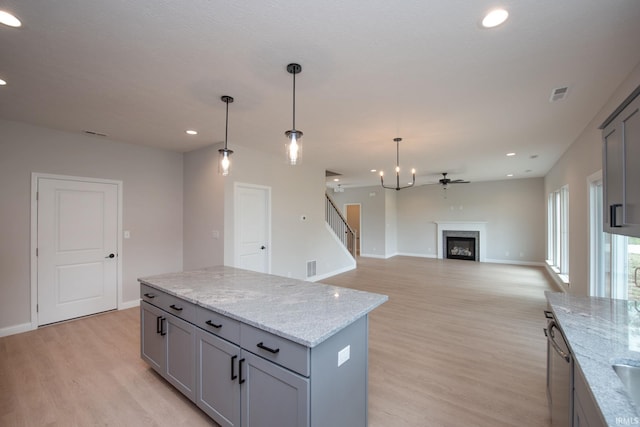 909 S Hoke Ave, Frankfort, IN 46041 - kitchen with gray cabinetry, recessed lighting, light wood-style flooring, a center island, and baseboards