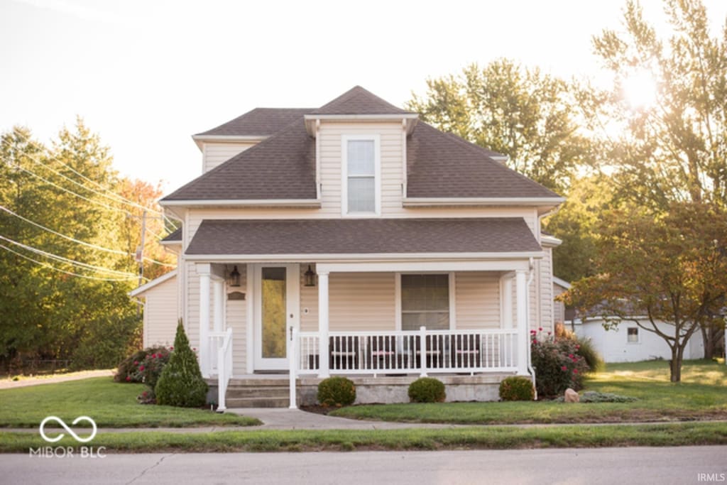 203 N Cross St, Hillsboro, IN 47949 - view of front facade with roof with shingles, covered porch, and a front lawn