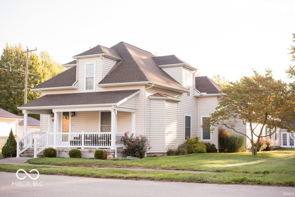 203 N Cross St, Hillsboro, IN 47949 - view of front of home featuring a porch, a front yard, and roof with shingles