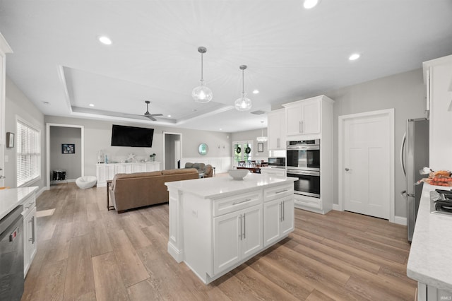 7018 S 350 St E, Lafayette, IN 47909 - kitchen featuring appliances with stainless steel finishes, a ceiling fan, a tray ceiling, light wood finished floors, and white cabinets