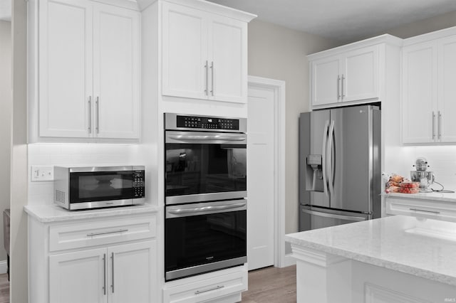 7018 S 350 St E, Lafayette, IN 47909 - kitchen with appliances with stainless steel finishes, white cabinets, backsplash, light wood-style flooring, and light stone counters