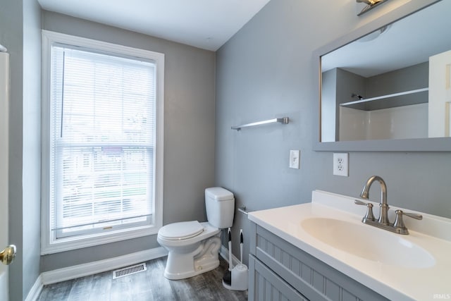 807 W Washington Blvd, Fort Wayne, IN 46802 - bathroom with baseboards, toilet, wood finished floors, vanity, and healthy amount of natural light