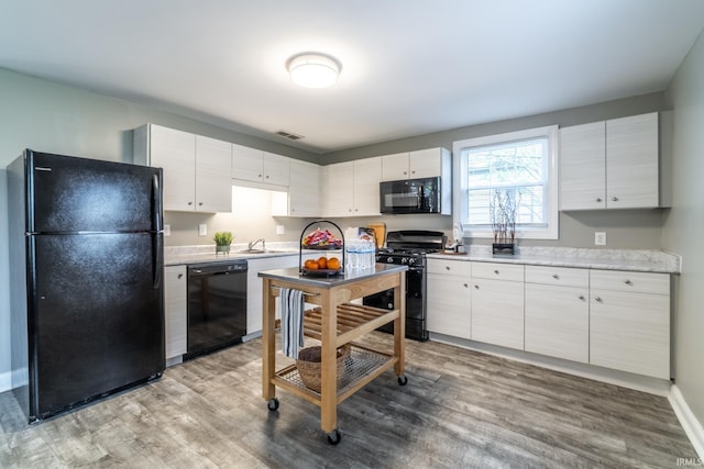 807 W Washington Blvd, Fort Wayne, IN 46802 - kitchen with black appliances, light countertops, light wood finished floors, and a sink