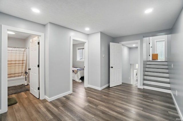 202 E Pickwick Dr, Syracuse, IN 46567 - unfurnished living room with baseboards, dark wood finished floors, recessed lighting, and stairs