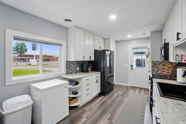 202 E Pickwick Dr, Syracuse, IN 46567 - kitchen featuring refrigerator, backsplash, freestanding refrigerator, white cabinets, and recessed lighting