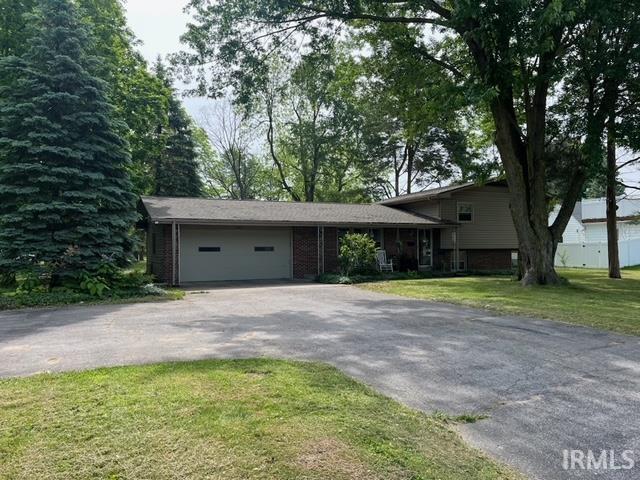 6403 Old Trail Rd, Fort Wayne, IN 46809 - tri-level home with asphalt driveway, an attached garage, a front yard, and brick siding