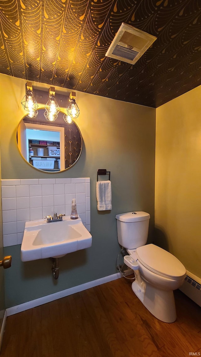 6403 Old Trail Rd, Fort Wayne, IN 46809 - half bath with a sink, toilet, wood finished floors, a baseboard radiator, and decorative backsplash