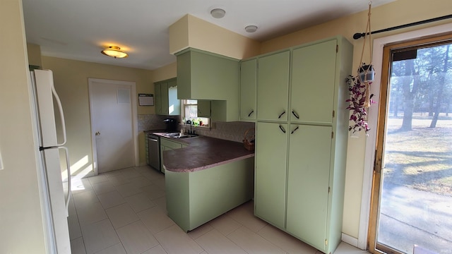 6403 Old Trail Rd, Fort Wayne, IN 46809 - kitchen with green cabinets, freestanding refrigerator, dark countertops, a sink, and backsplash