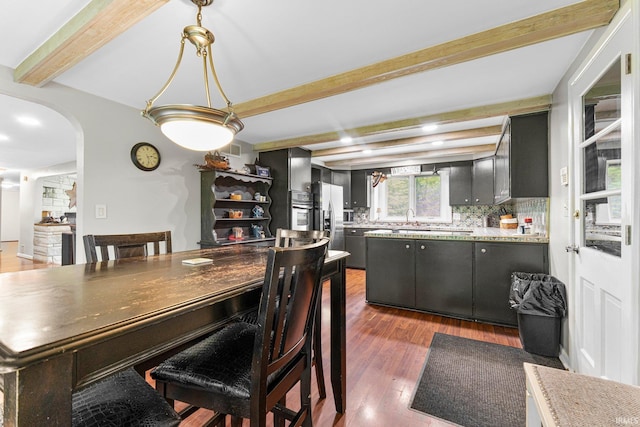 10317 Bass Rd, Fort Wayne, IN 46818 - dining space with wood finished floors, beam ceiling, and arched walkways