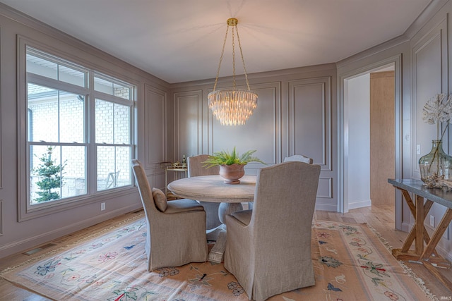 2909 Lake Dr, Newburgh, IN 47630 - dining area with a decorative wall, a chandelier, healthy amount of natural light, light wood-style floors, and baseboards