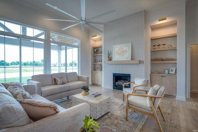2909 Lake Dr, Newburgh, IN 47630 - living area featuring built in features, ceiling fan, plenty of natural light, a large fireplace, and crown molding