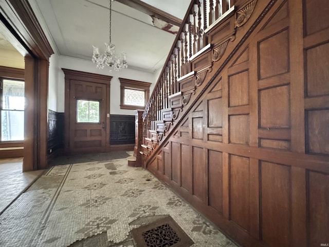 806 E Market St, Logansport, IN 46947 - carpeted foyer entrance with a chandelier, stairs, a wainscoted wall, a decorative wall, and crown molding