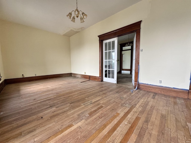 806 E Market St, Logansport, IN 46947 - empty room featuring wood-type flooring, a chandelier, and baseboards