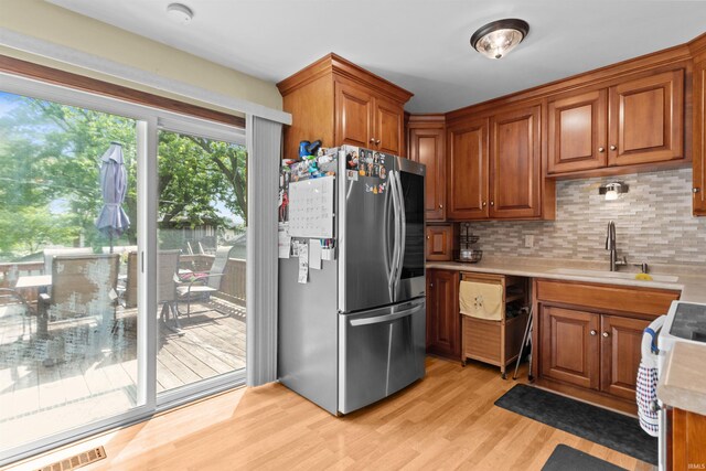 1804 Saint Charles Ct, Kokomo, IN 46902 - kitchen with freestanding refrigerator, a sink, light countertops, light wood-style floors, and decorative backsplash