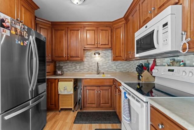 1804 Saint Charles Ct, Kokomo, IN 46902 - kitchen with white appliances, a sink, brown cabinets, light countertops, and backsplash