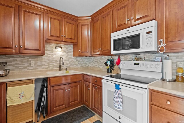 1804 Saint Charles Ct, Kokomo, IN 46902 - kitchen featuring white appliances, a sink, light countertops, decorative backsplash, and brown cabinetry