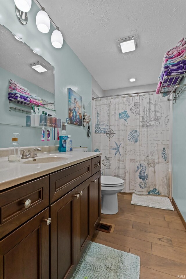 1804 Saint Charles Ct, Kokomo, IN 46902 - bathroom with wood finished floors, vanity, toilet, a textured ceiling, and a shower with curtain