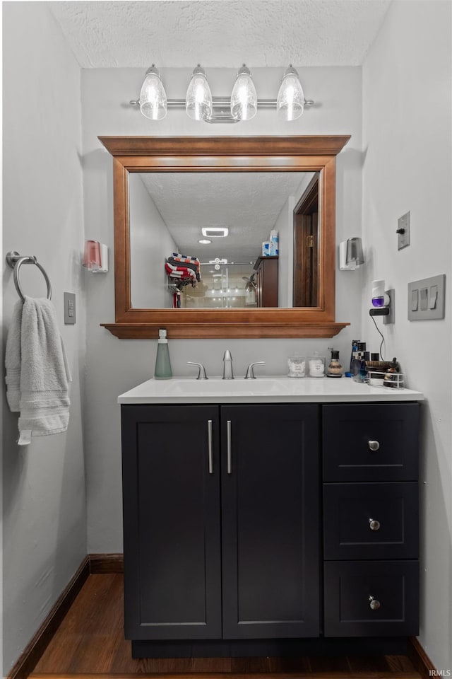 1804 Saint Charles Ct, Kokomo, IN 46902 - bathroom featuring vanity, wood finished floors, a textured ceiling, and baseboards