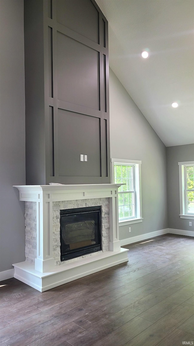 2022 W Blackberry Trl, Warsaw, IN 46582 - unfurnished living room featuring baseboards, lofted ceiling, a fireplace, wood finished floors, and recessed lighting