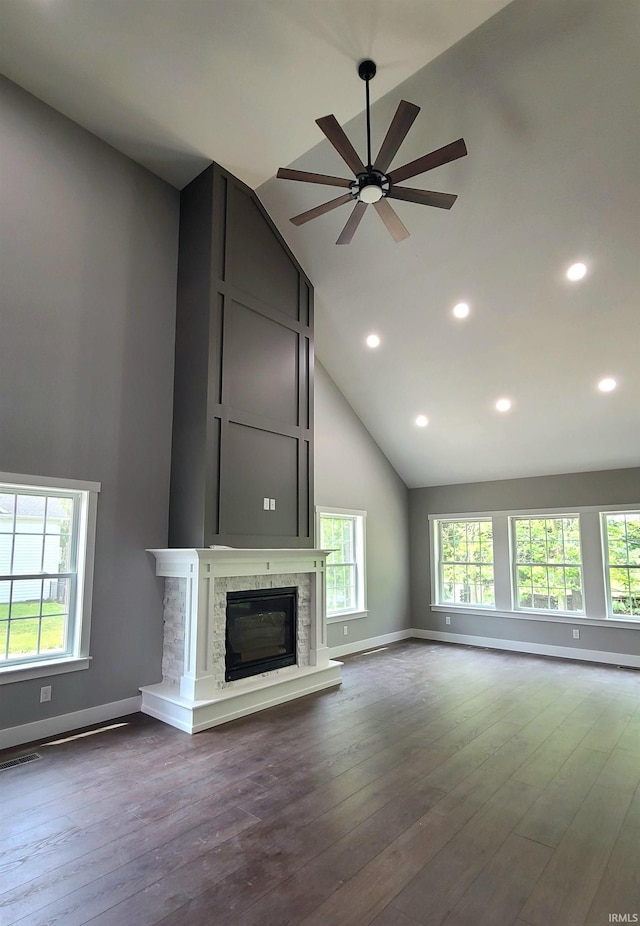 2022 W Blackberry Trl, Warsaw, IN 46582 - unfurnished living room with high vaulted ceiling, ceiling fan, baseboards, dark wood-type flooring, and a glass covered fireplace