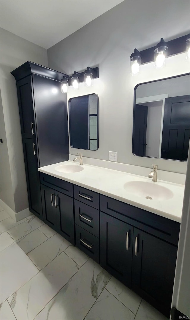 2022 W Blackberry Trl, Warsaw, IN 46582 - bathroom with double vanity, marble look tile flooring, and baseboards
